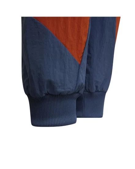 Un pantalon de survêtement tissé sport conçu en matériaux recyclés. Enfant B CB